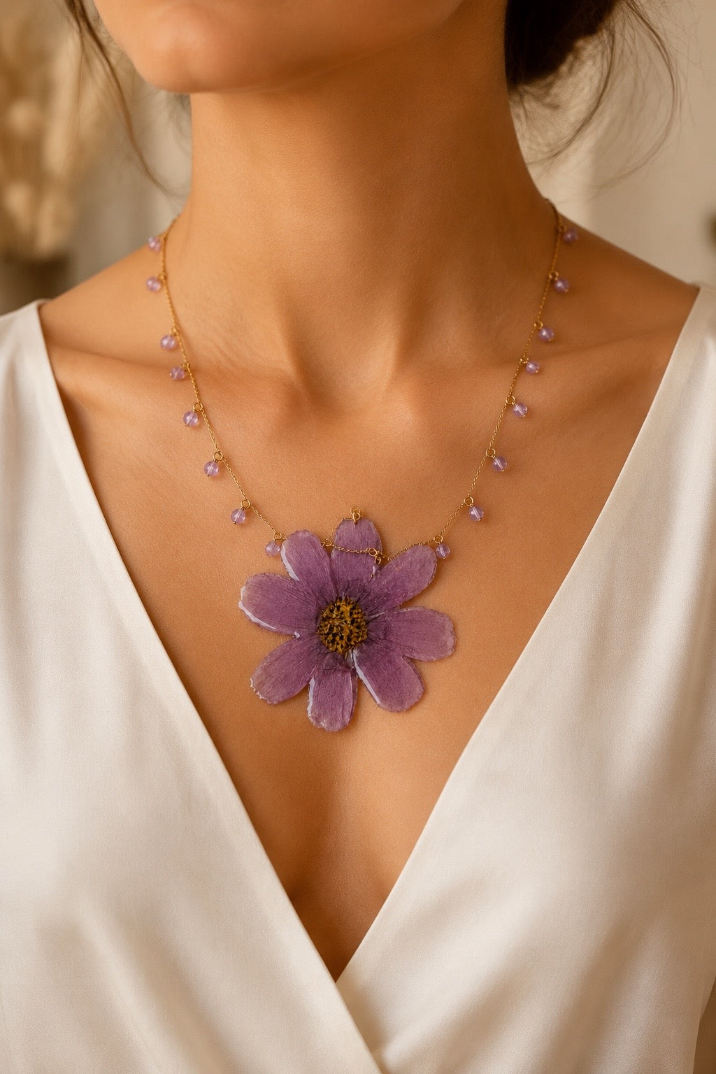 Purple preserved flower statement necklace worn with an ivory dress